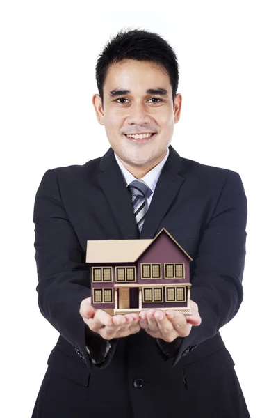 Businessman showing small house — Stockfoto