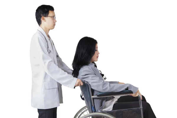 Doctor pushing wheelchair with disabled patient — Stock Photo, Image