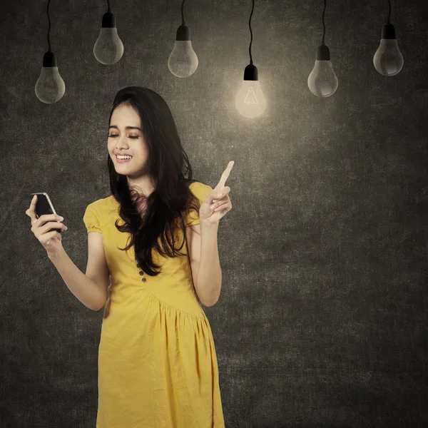 Dívka použití mobil pod lampy — Stock fotografie