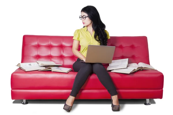 Mooie student zittend op de bank terwijl het bestuderen van — Stockfoto