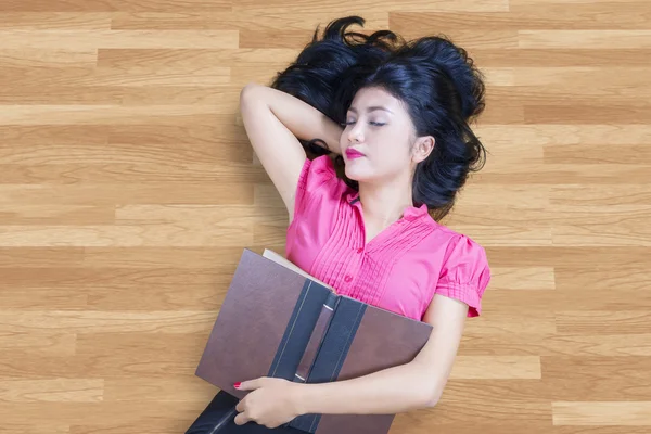 Student hält Buch in der Hand und schläft auf dem Boden — Stockfoto