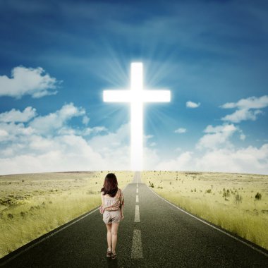 Casual girl walking toward a cross