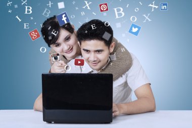 Couple using social network site on laptop