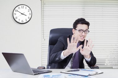 Fear businessman with hand gesture in office