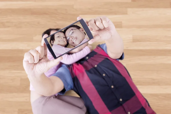 Father and his child taking photo on the floor — Zdjęcie stockowe