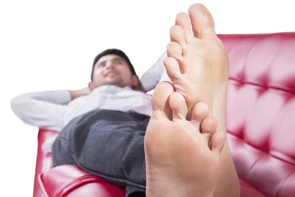 Feet of young man lying on couch — Stok fotoğraf