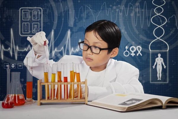 Pequeno estudante jogando fluido químico — Fotografia de Stock