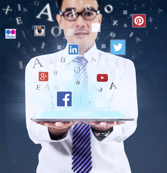 Homme tenant tablette avec des symboles de médias sociaux — Photo