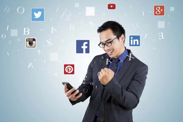 Hombre de negocios exitoso utilizando la red social en el teléfono celular —  Fotos de Stock
