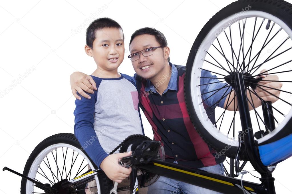 Little boy and his dad after fixing a bike