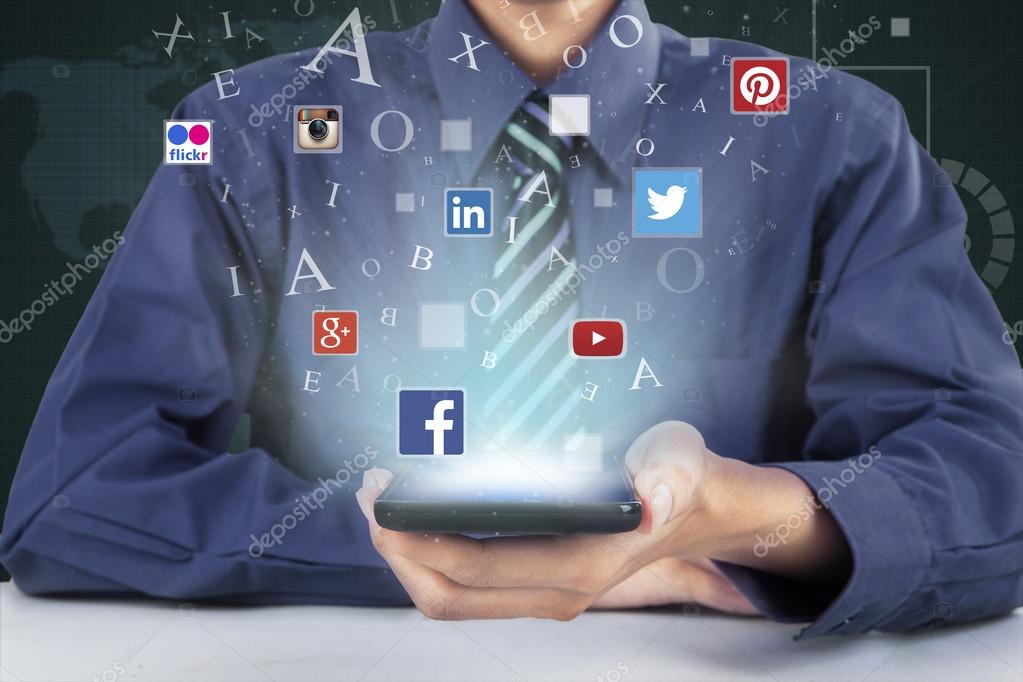 JAKARTA, SEPTEMBER 21, 2015: Image of businessperson hand showing mobile phone with social media symbols