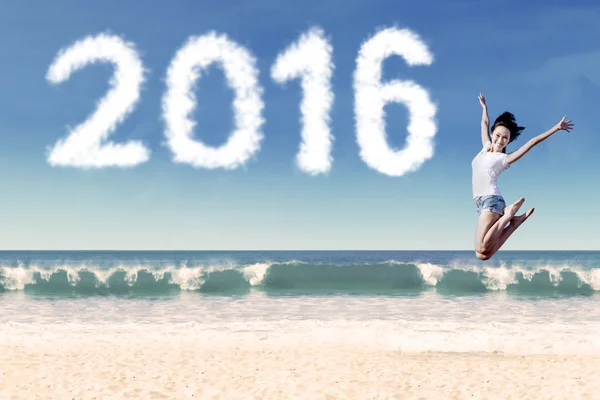 Attractive woman jumping at coast with numbers 2016 — Stock Photo, Image