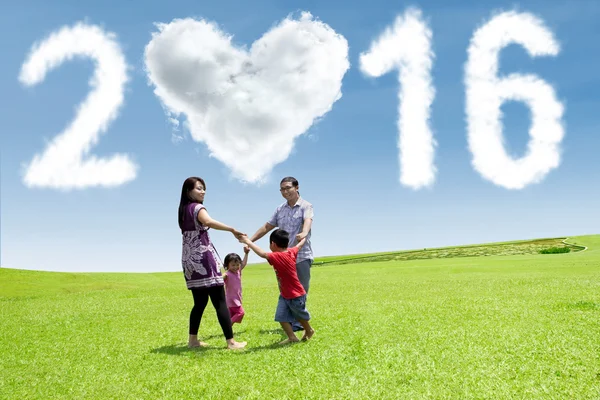 Familia jugando en el campo con los números 2016 — Foto de Stock