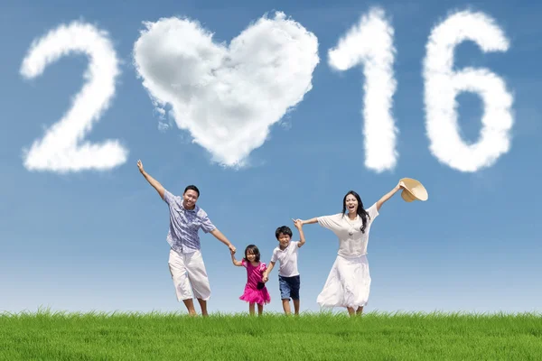 Familia alegre corriendo bajo los números 2016 —  Fotos de Stock