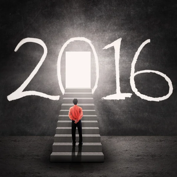 Hombre mirando a la puerta brillante con números 2016 —  Fotos de Stock