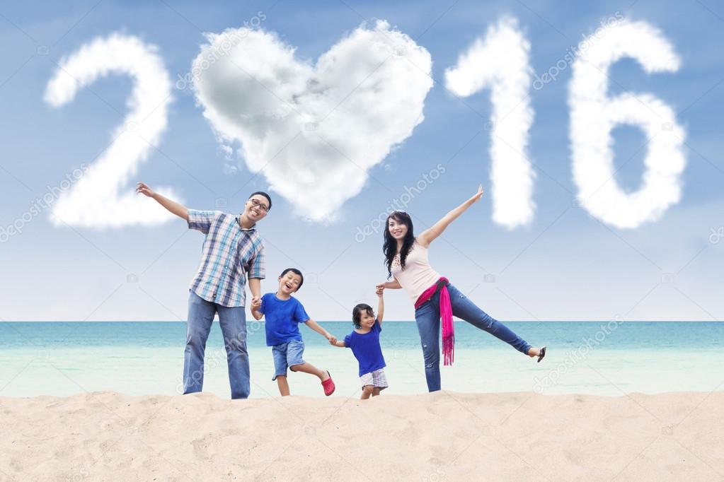 Happy family on beach with numbers 2016