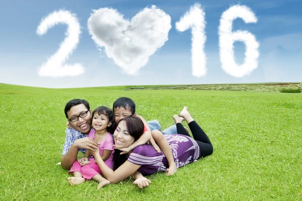 Família asiática relaxante no campo com números de 2016 — Fotografia de Stock