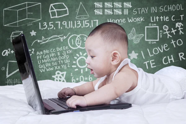 Bambino attraente utilizzando laptop con sfondo scarabocchiare — Foto Stock