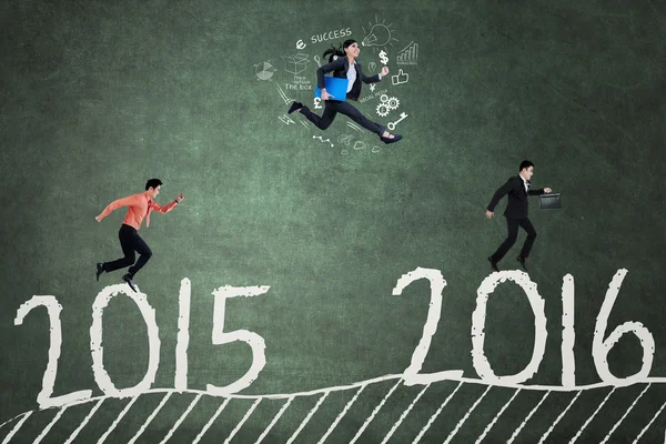 Business team jumps above numbers 2015 to 2016 — Stock Photo, Image