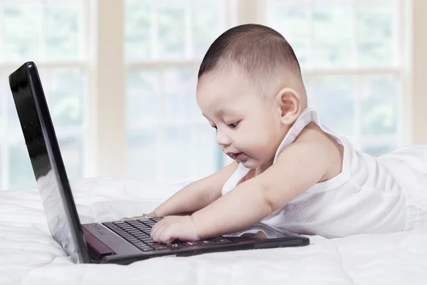 Alegre masculino bebê digitação no laptop — Fotografia de Stock