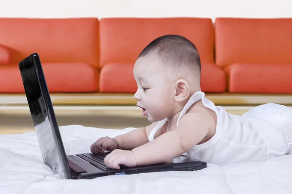 Cleveres Baby mit Laptop zu Hause — Stockfoto