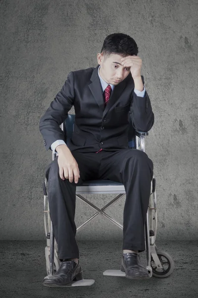 Депрессивный работник сидит на инвалидной коляске — стоковое фото