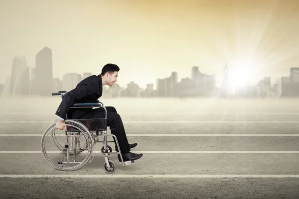 Disabled businessman pushing wheelchair outdoors — Stock Photo, Image