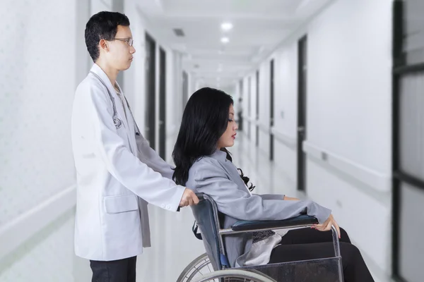 Läkare driver patienten med rullstol på sjukhus — Stockfoto