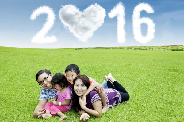 Familie liegt auf Gras mit Zahlen 2016 — Stockfoto