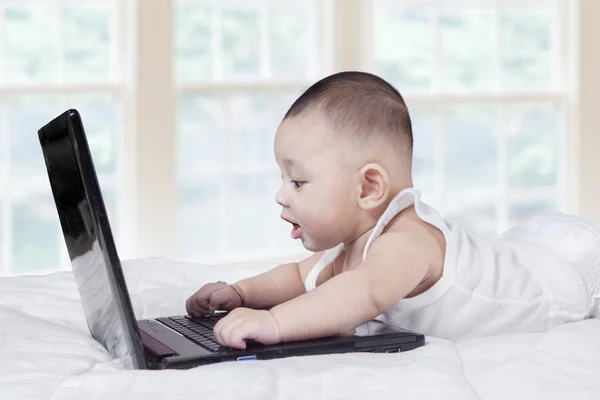 Criança do sexo masculino jogando notebook computador em casa — Fotografia de Stock