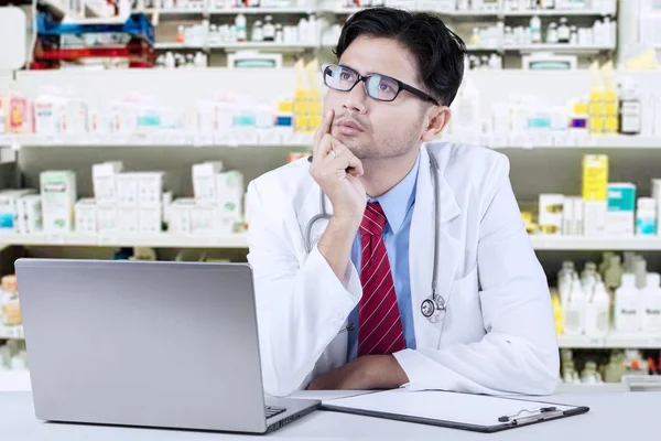 Farmacéutico pensativo en la farmacia —  Fotos de Stock