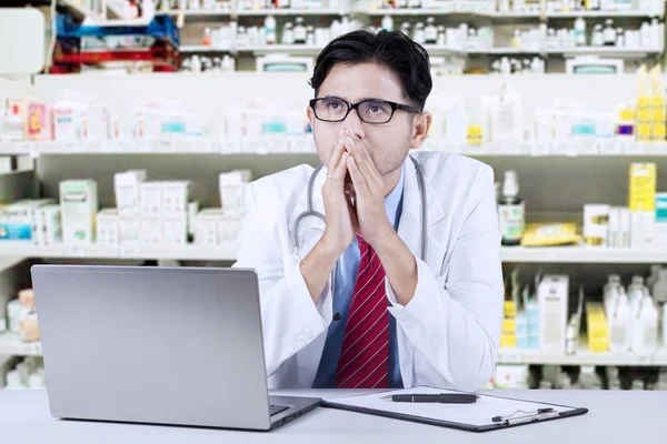 Cuidadoso farmacéutico sentado en la farmacia —  Fotos de Stock
