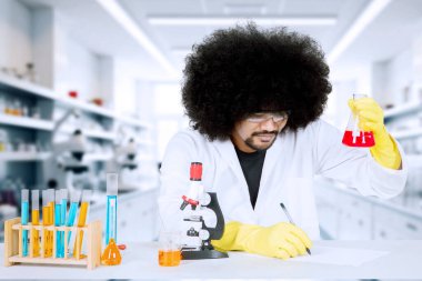 Erkek Bilim Adamı Laboratuvarda Konik Şişede Kimyasal İnceleme Yapıyor