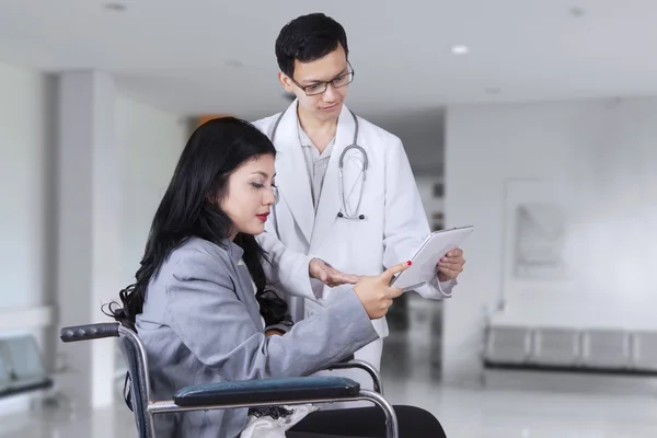 Médico mostrando relatório médico em paciente com deficiência — Fotografia de Stock