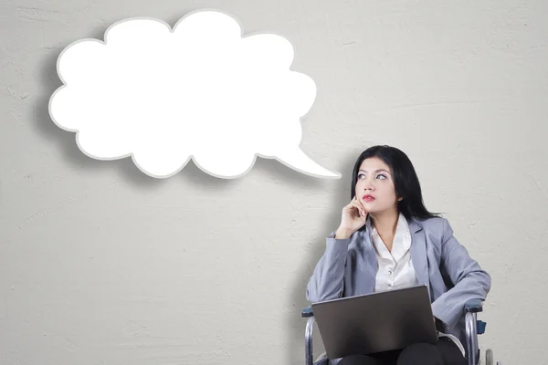 Disabled woman with laptop looking at speech bubble — Stock Photo, Image