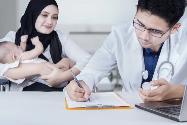 Madre y bebé esperando médico hace receptor — Foto de Stock