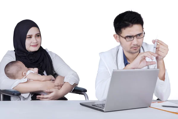 Madre y bebé con el médico sostiene la jeringa — Foto de Stock