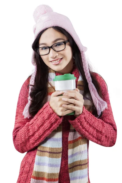 Sladká dívka, která nosí teplé oblečení a drží horký nápoj — Stock fotografie