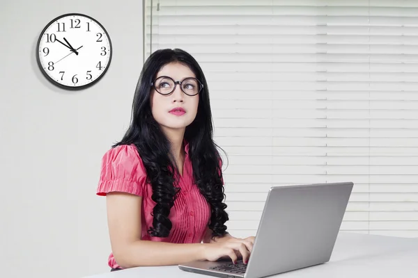 Donna con computer portatile e orologio in ufficio — Foto Stock