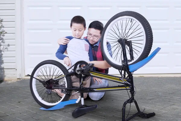 Dziecko i tata naprawianie uszkodzony rowerowych — Zdjęcie stockowe