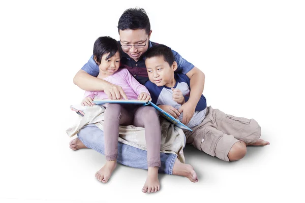Тато з двома дітьми читає книгу оповідань — стокове фото