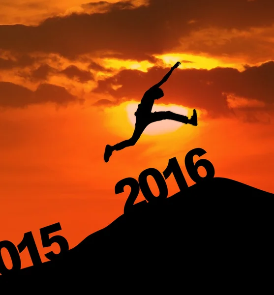 Man jumping over 2016 number at hill — Stock Photo, Image