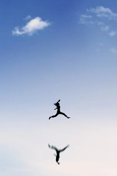 Žena si dovolenou a skoky na obloze — Stock fotografie