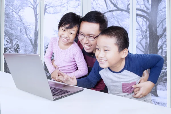 Jeune père et les enfants s'amuser avec un ordinateur portable — Photo