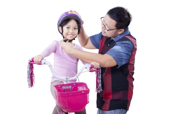 Jovem prende o capacete na cabeça da criança — Fotografia de Stock