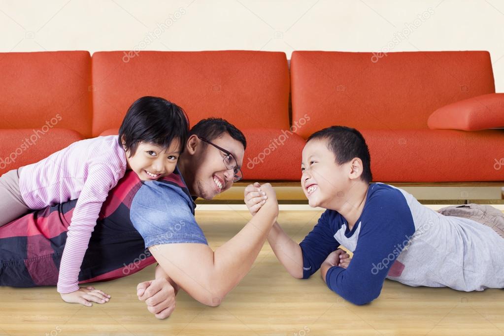 Cute boy arm wrestling with his dad