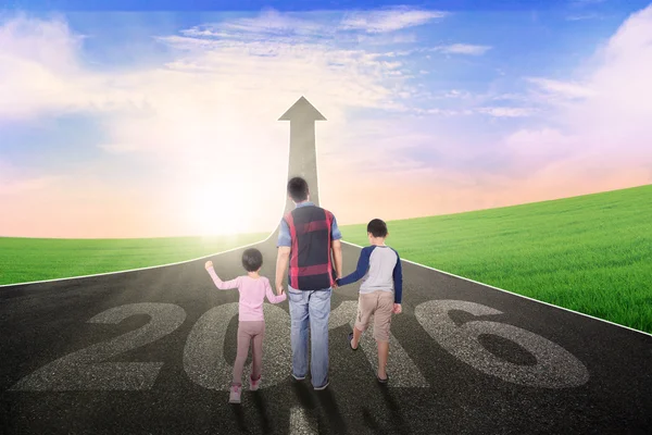 Kinderen en vader wandelingen op de weg met getallen 2016 — Stockfoto