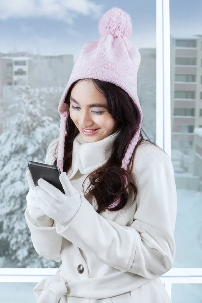 Mädchen im Wintermantel textet mit Smartphone — Stockfoto