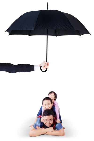 Children and dad lying in studio under umbrella — 图库照片