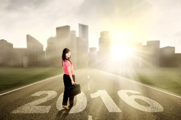 Chinese worker on the road with numbers 2016 — Stock Photo, Image